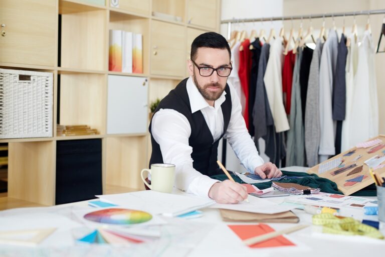 Kreatywny projektant szkicujący modelki w swoim studiu